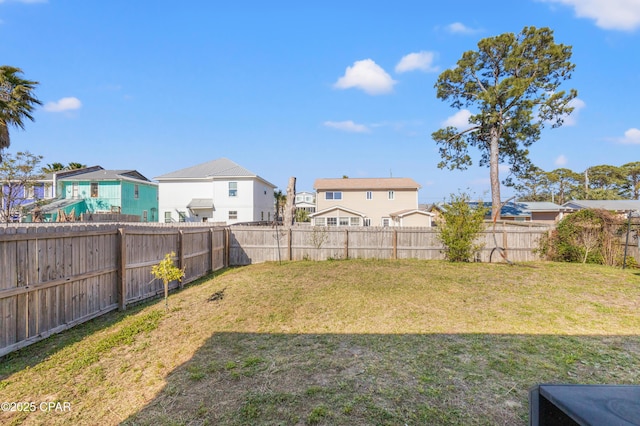 view of yard featuring a fenced backyard and a residential view