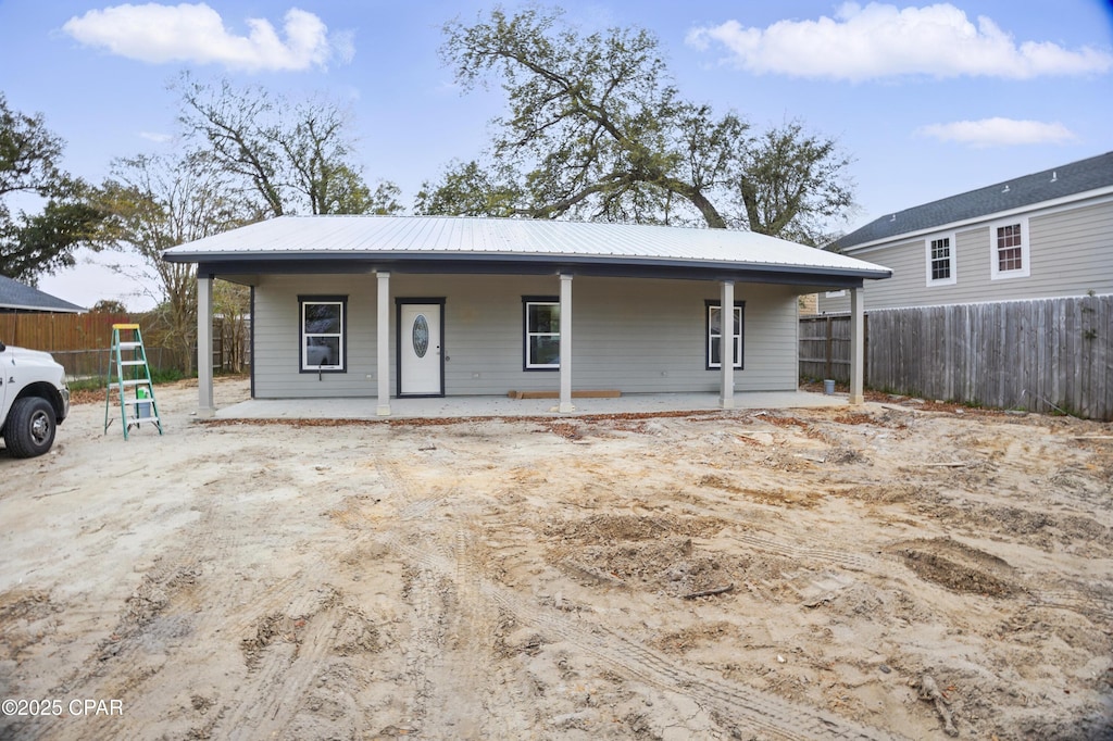 view of front facade featuring fence, a porch, and metal roof