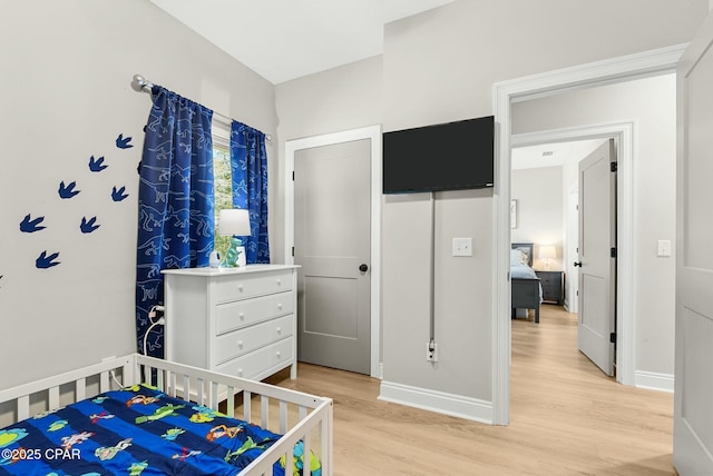 bedroom with baseboards and light wood-style flooring