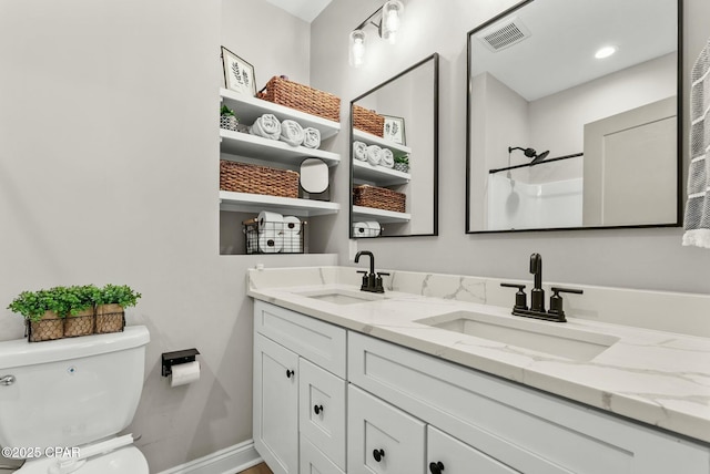 bathroom featuring toilet, a sink, double vanity, and visible vents