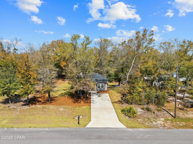 view of front of home with a front yard and concrete driveway