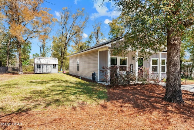 exterior space with a front yard, an outdoor structure, board and batten siding, and a storage shed