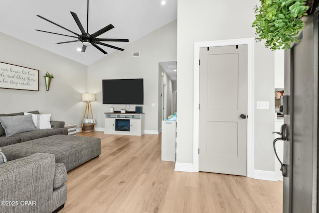 living area featuring baseboards, ceiling fan, visible vents, and light wood-style floors