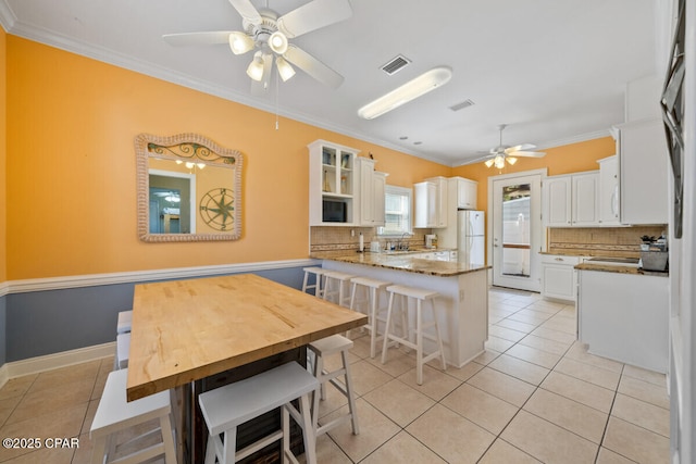14205 Millcole Ave, Panama City Beach, FL 32413 - kitchen with freestanding refrigerator, tasteful backsplash, visible vents, and a ceiling fan