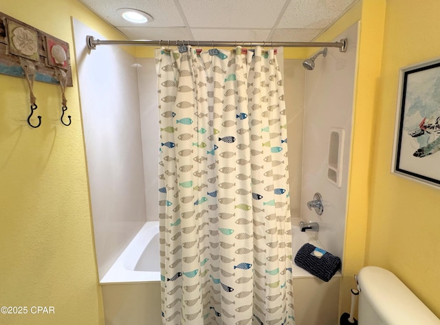 full bathroom with toilet, a drop ceiling, and shower / bathtub combination with curtain