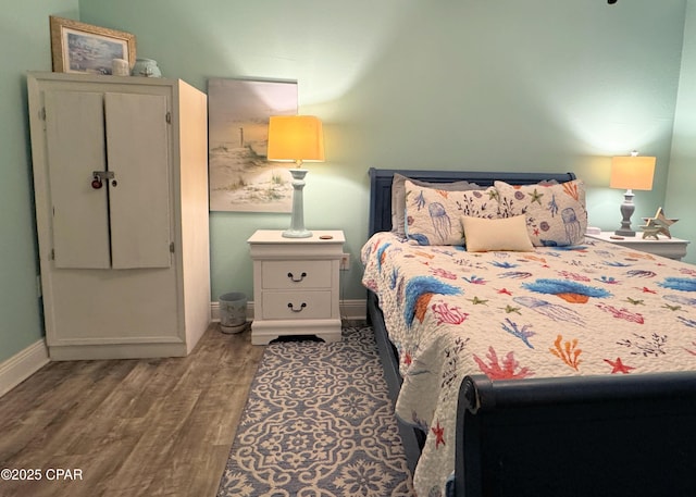 bedroom with baseboards and wood finished floors