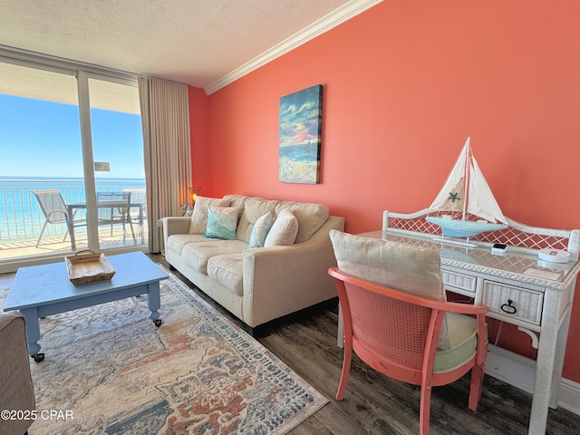 living area featuring floor to ceiling windows, a textured ceiling, crown molding, wood finished floors, and a water view