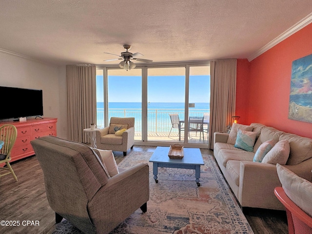 living area featuring ceiling fan, floor to ceiling windows, ornamental molding, and wood finished floors