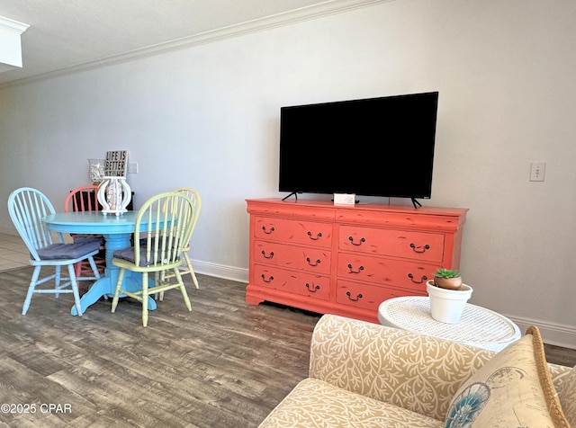 living area featuring baseboards, ornamental molding, and wood finished floors