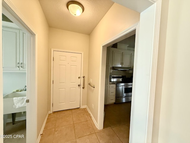2557 Woods View Dr, Marianna, FL 32446 - corridor with baseboards, a textured ceiling, and light tile patterned floors