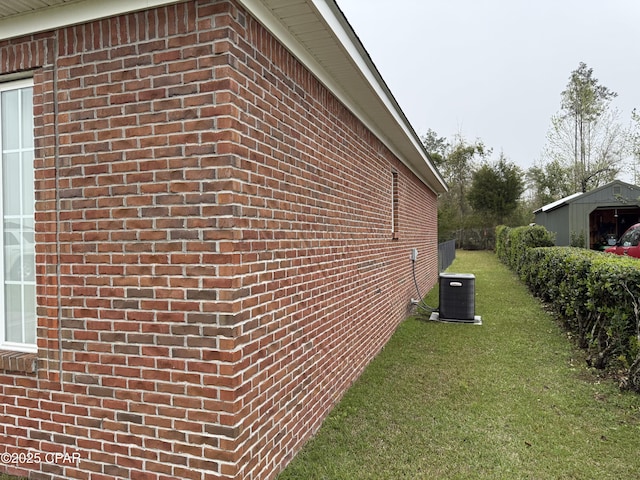 2557 Woods View Dr, Marianna, FL 32446 - view of side of home featuring central air condition unit, a lawn, and brick siding
