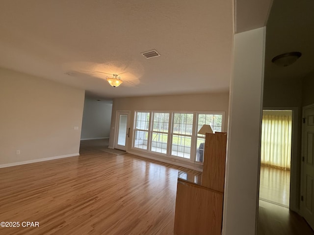 2557 Woods View Dr, Marianna, FL 32446 - unfurnished living room featuring baseboards, visible vents, wood finished floors, and a textured ceiling