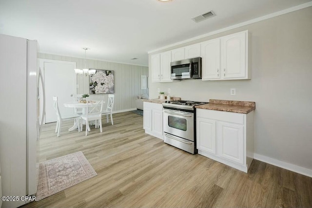 kitchen featuring light wood-style flooring, appliances with stainless steel finishes, and baseboards