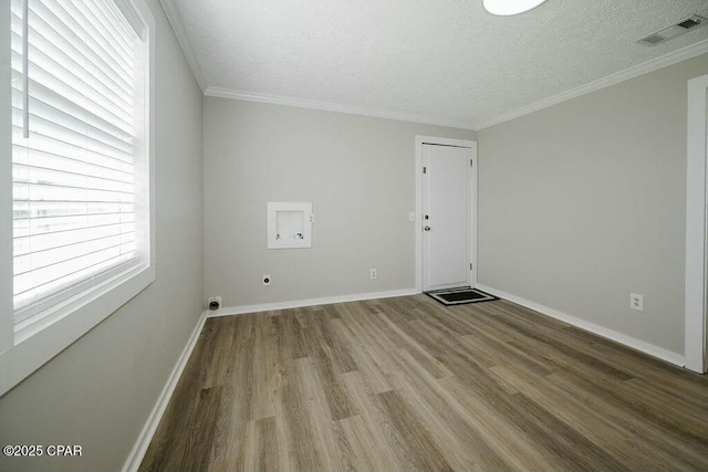 unfurnished room with visible vents, a textured ceiling, baseboards, and wood finished floors