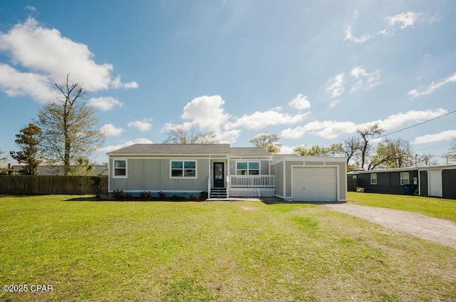 manufactured / mobile home with an attached garage, a front yard, fence, and dirt driveway