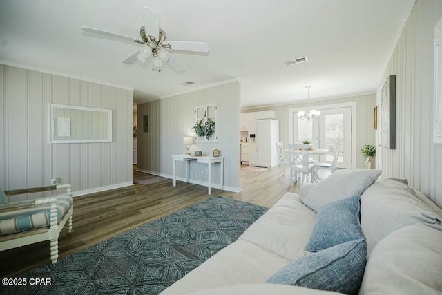 living area featuring ornamental molding, visible vents, baseboards, and wood finished floors