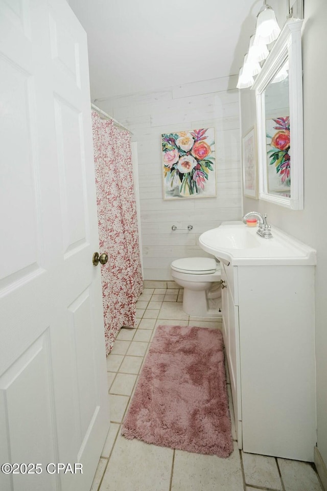 bathroom featuring a shower with shower curtain, tile patterned flooring, vanity, and toilet