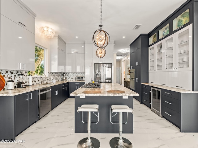 103 Harbour Pointe Dr, Lynn Haven, FL 32444 - kitchen with stainless steel appliances, wine cooler, a center island, light marble finish flooring, and a breakfast bar