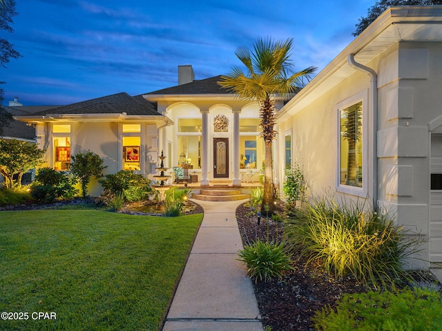 103 Harbour Pointe Dr, Lynn Haven, FL 32444 - doorway to property featuring a lawn, stucco siding, and a chimney
