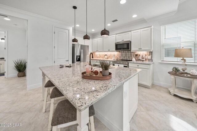 kitchen with decorative backsplash, crown molding, a kitchen island with sink, stainless steel appliances, and white cabinetry