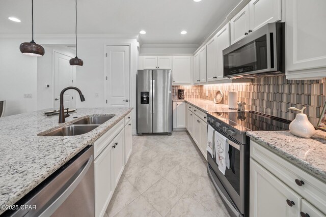 kitchen featuring white cabinets, crown molding, stainless steel appliances, tasteful backsplash, and a sink