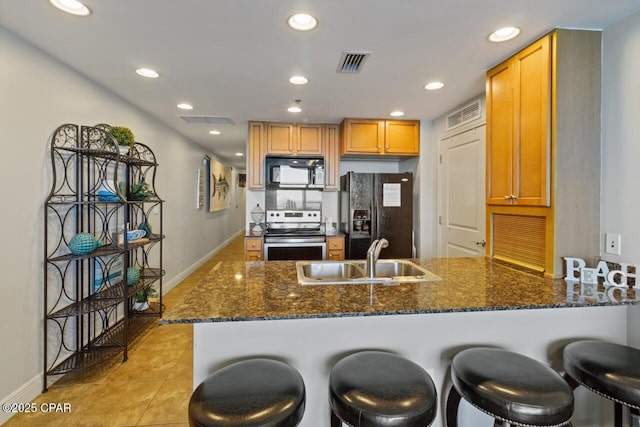 16701 Front Beach Rd Unit 1803, Panama City Beach, FL 32413 - kitchen featuring black appliances, a peninsula, a sink, dark stone counters, and recessed lighting