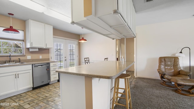 810 Virginia Ave, Lynn Haven, FL 32444 - kitchen with stainless steel dishwasher, french doors, white cabinetry, a breakfast bar area, and decorative light fixtures