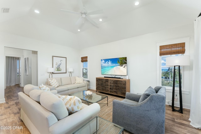 living area featuring vaulted ceiling, wood finished floors, and baseboards