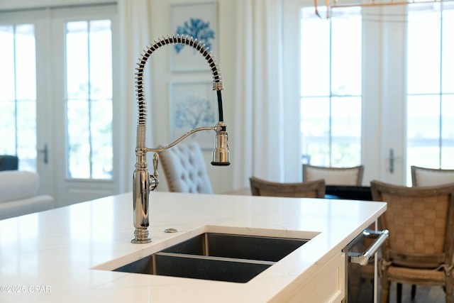 interior details featuring light countertops, white cabinets, and a sink