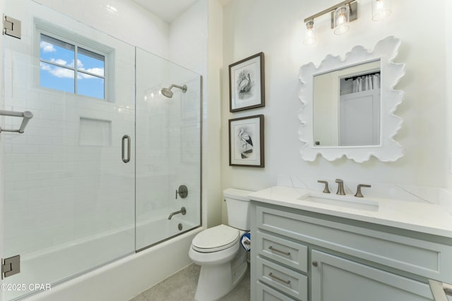 full bathroom featuring toilet, tile patterned flooring, bath / shower combo with glass door, and vanity