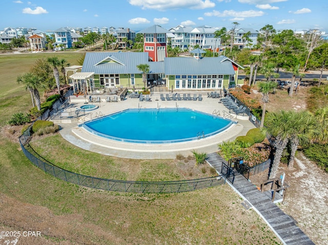 community pool with fence, a patio, and a residential view