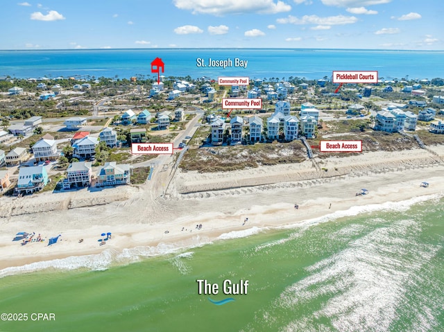 birds eye view of property featuring a beach view and a water view