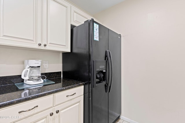 520 N Richard Jackson Blvd Unit 1804, Panama City Beach, FL 32407 - kitchen featuring black fridge, dark stone countertops, and white cabinets