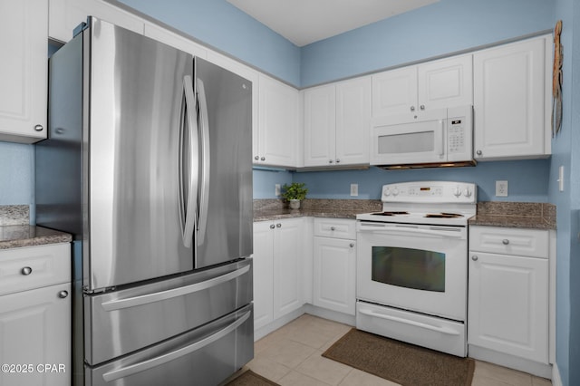 14701 Front Beach Rd Unit 2128, Panama City Beach, FL 32413 - kitchen with white appliances, white cabinetry, light tile patterned floors, and dark stone counters
