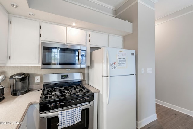 17878 Front Beach Rd Unit B2, Panama City Beach, FL 32413 - kitchen with light countertops, white cabinets, baseboards, ornamental molding, and appliances with stainless steel finishes