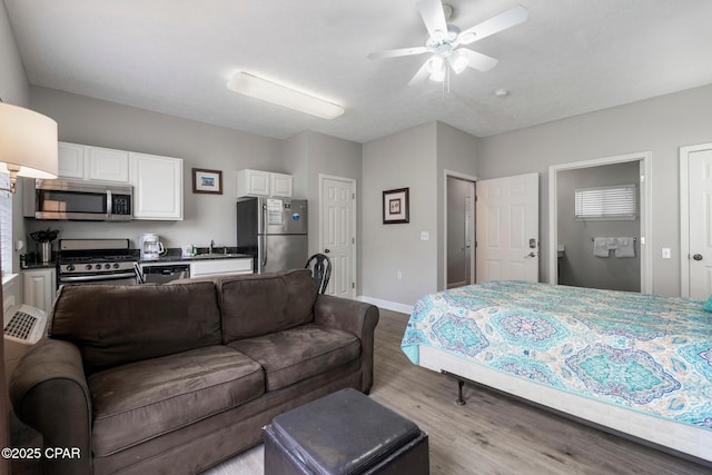 17878 Front Beach Rd Unit B2, Panama City Beach, FL 32413 - bedroom with a sink, freestanding refrigerator, wood finished floors, ensuite bathroom, and baseboards