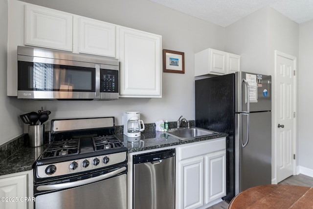 17878 Front Beach Rd Unit B2, Panama City Beach, FL 32413 - kitchen with white cabinetry, a sink, stainless steel appliances, and dark stone counters