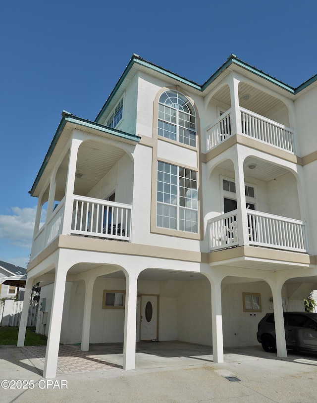 17878 Front Beach Rd Unit B2, Panama City Beach, FL 32413 - rear view of property featuring stucco siding and a carport