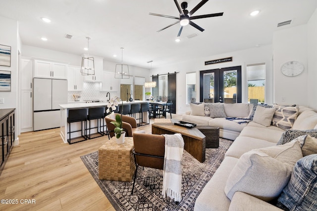 314 Tanaga St, Panama City Beach, FL 32413 - living area featuring a ceiling fan, light wood-style flooring, recessed lighting, a barn door, and french doors