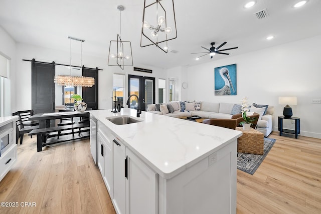 314 Tanaga St, Panama City Beach, FL 32413 - kitchen featuring a sink, a barn door, recessed lighting, light wood finished floors, and a chandelier