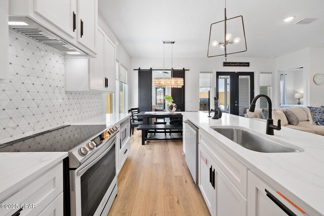314 Tanaga St, Panama City Beach, FL 32413 - kitchen featuring stainless steel appliances, a sink, a chandelier, light wood-style flooring, and backsplash