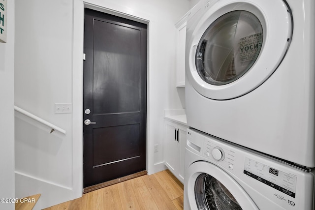 314 Tanaga St, Panama City Beach, FL 32413 - laundry room featuring stacked washer / dryer, light wood-style flooring, and cabinet space