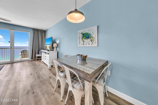 dining space with baseboards and light wood finished floors
