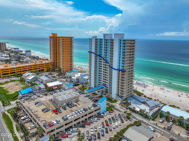 drone / aerial view with a water view, a view of the beach, and a city view