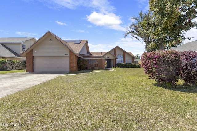1606 Belmont Blvd, Lynn Haven, FL 32444 - view of front facade with an attached garage, roof mounted solar panels, brick siding, and a front lawn