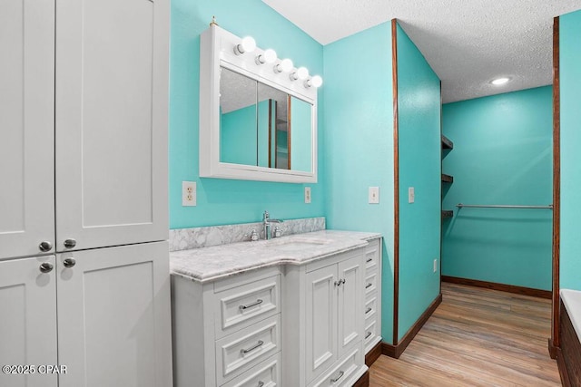 2089 Pike Pond Rd, Alford, FL 32420 - full bath featuring vanity, wood finished floors, a textured ceiling, and a walk in closet
