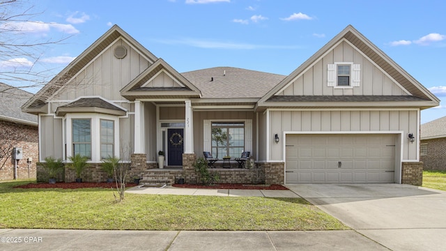 221 S Shoreview Dr, Panama City, FL 32404 - craftsman-style home with concrete driveway, a front yard, board and batten siding, roof with shingles, and brick siding