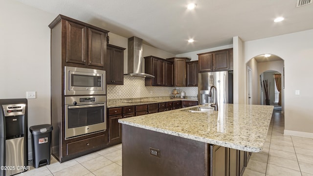 221 S Shoreview Dr, Panama City, FL 32404 - kitchen featuring appliances with stainless steel finishes, wall chimney exhaust hood, a sink, arched walkways, and light tile patterned floors