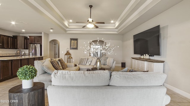 221 S Shoreview Dr, Panama City, FL 32404 - living area featuring arched walkways, light tile patterned floors, ceiling fan, a raised ceiling, and baseboards