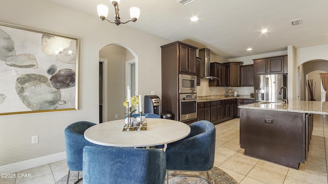 221 S Shoreview Dr, Panama City, FL 32404 - dining area featuring arched walkways, light tile patterned floors, a chandelier, vaulted ceiling, and baseboards